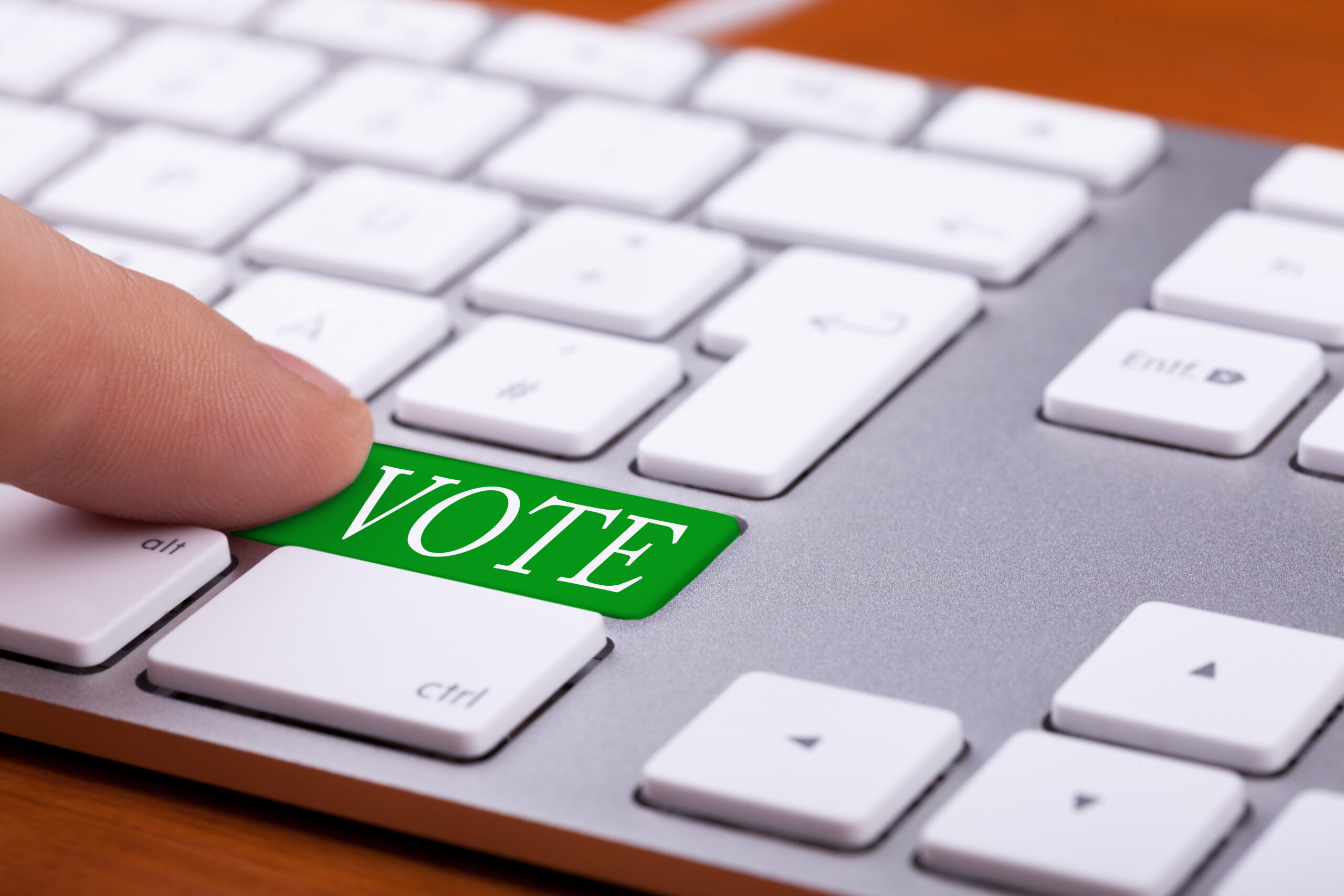 Finger pressing on vote green button on keyboard