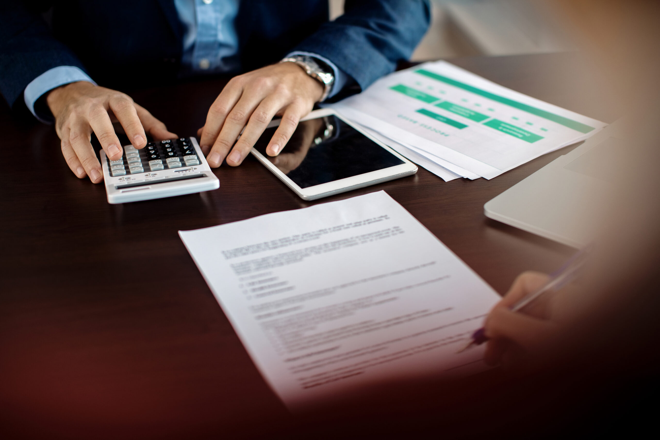 Close-up of insurance agent making calculations while signing ag